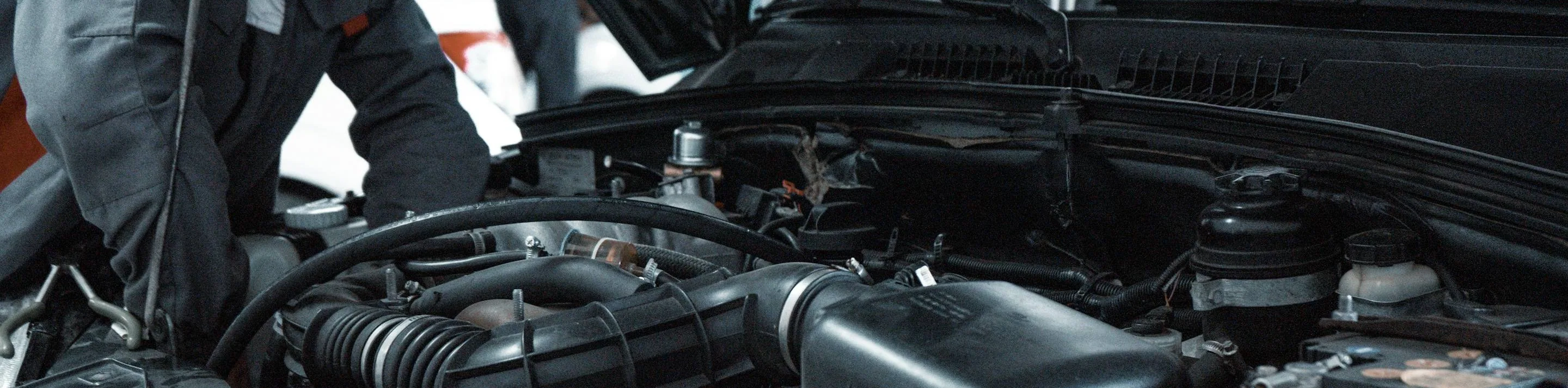 hands at work in an engine bay, wide