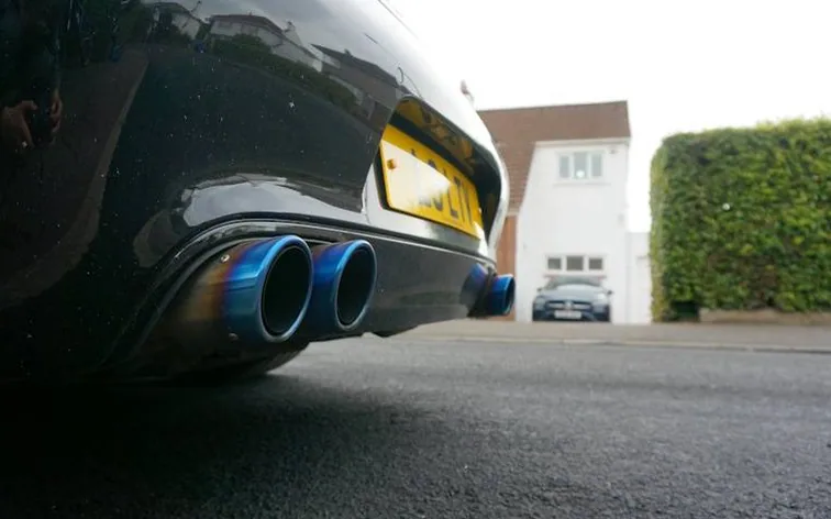 an exhaust tailpipe on a UK car, close — MOT retest