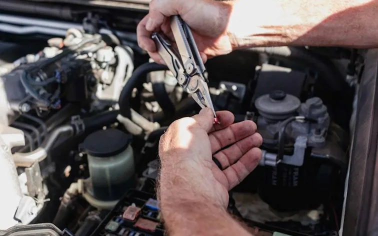 hands at work in an engine bay — service vs MOT
